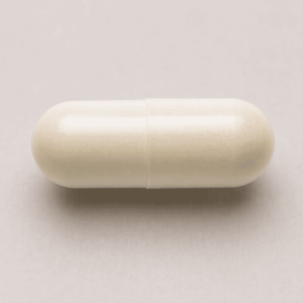 An opaque, off-white, smooth oblong capsule with rounded ends and a faint seam around its middle.