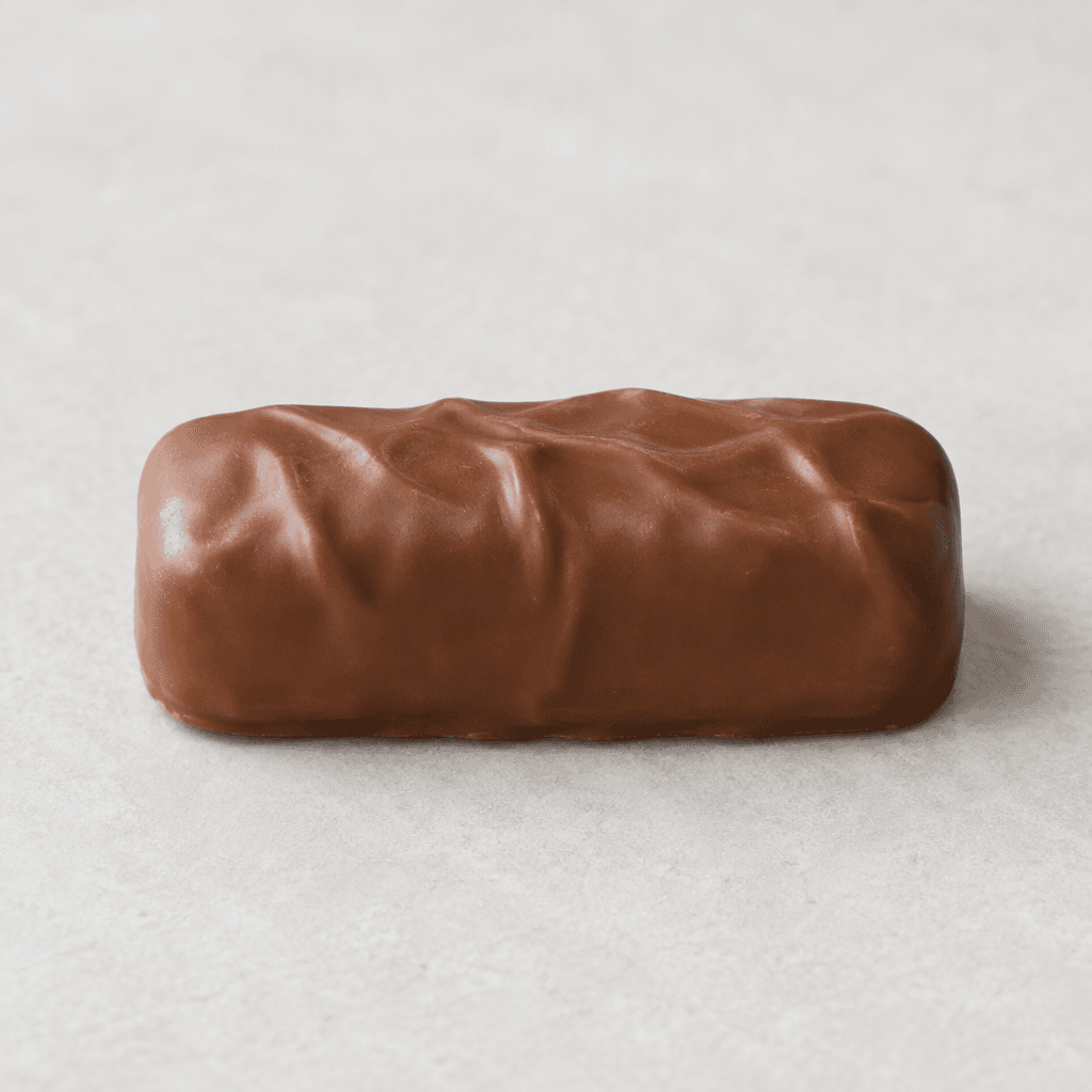 Köşeleri yuvarlatılmış, uzunca küçük bir bar; yüzeyinde hafif dalgalanmalar bulunan pürüzsüz sütlü çikolatayla kaplı.