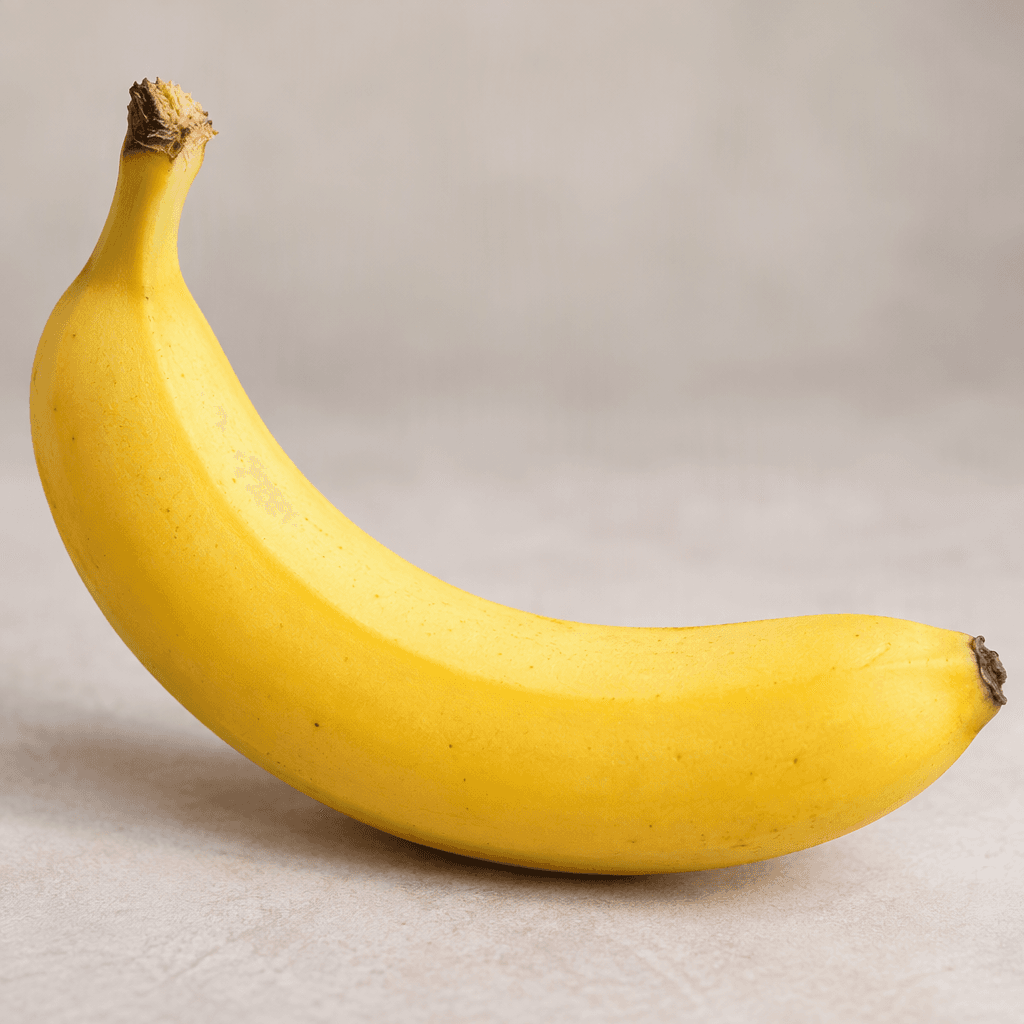 A ripe banana with smooth, bright yellow skin, a gently curved elongated shape, and small dark brown tips.