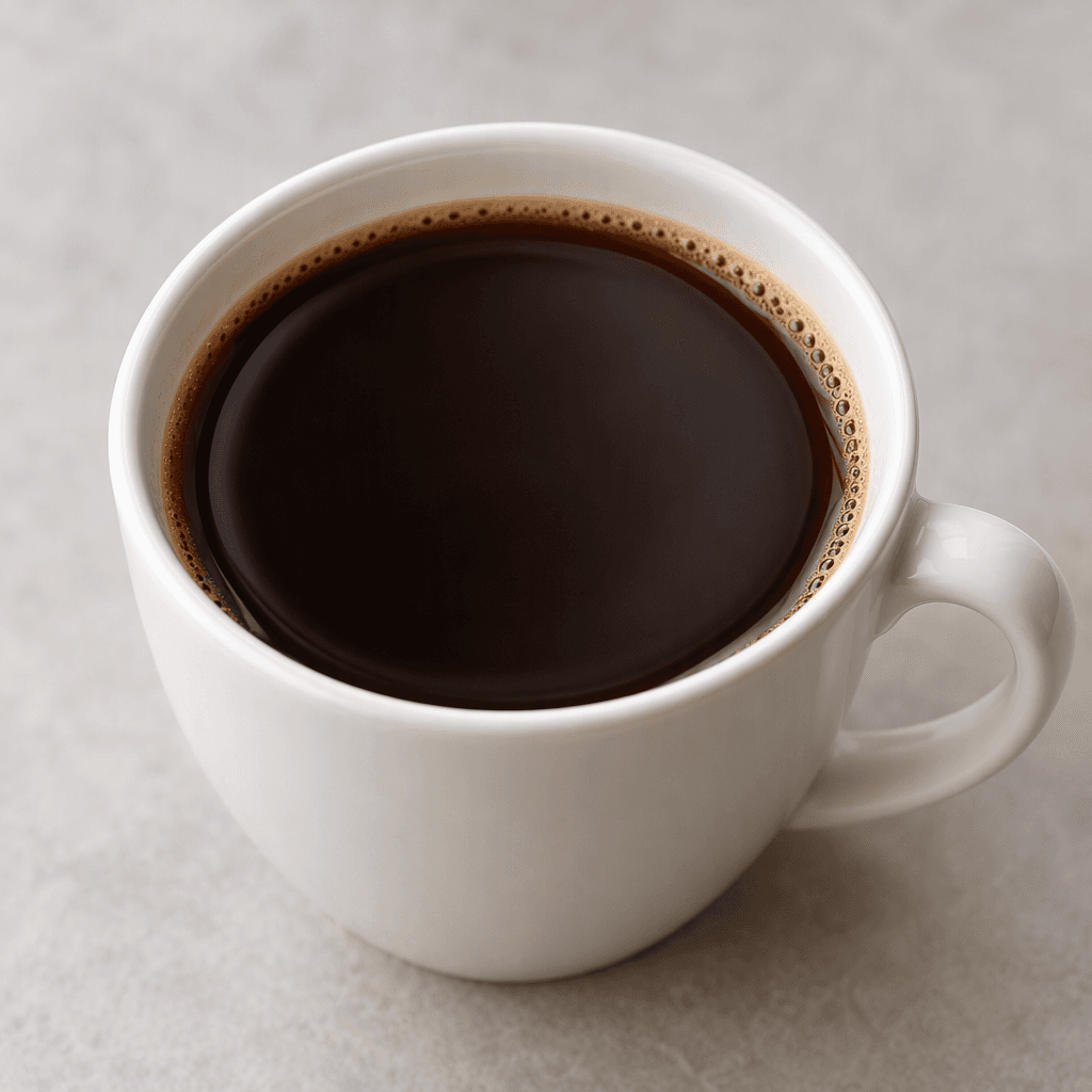 A cup of smooth, deep-brown coffee with a plain, unadorned surface.