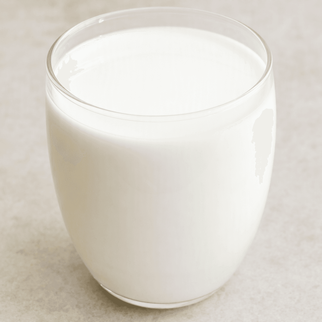 An opaque, bright-white liquid with a smooth, slightly glossy surface, filling a clear glass.