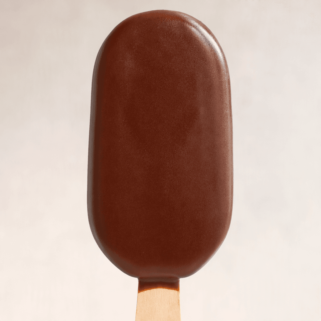 A dark-brown chocolate-coated ice cream bar with rounded ends, shown on a stick with a smooth, slightly glossy surface.