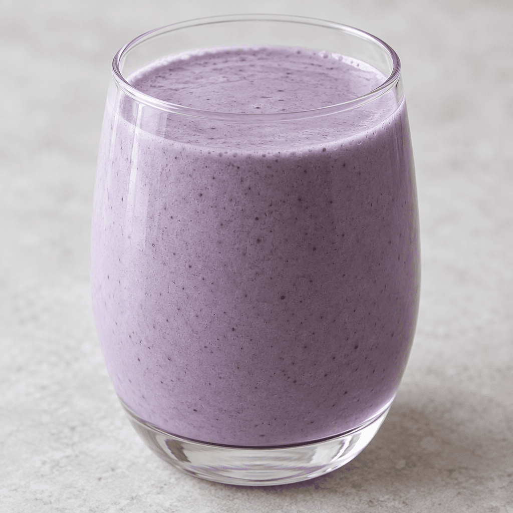 A smooth, pourable kefir drink in a pale blueberry-purple colour, with an even, creamy-looking surface and no visible fruit pieces.