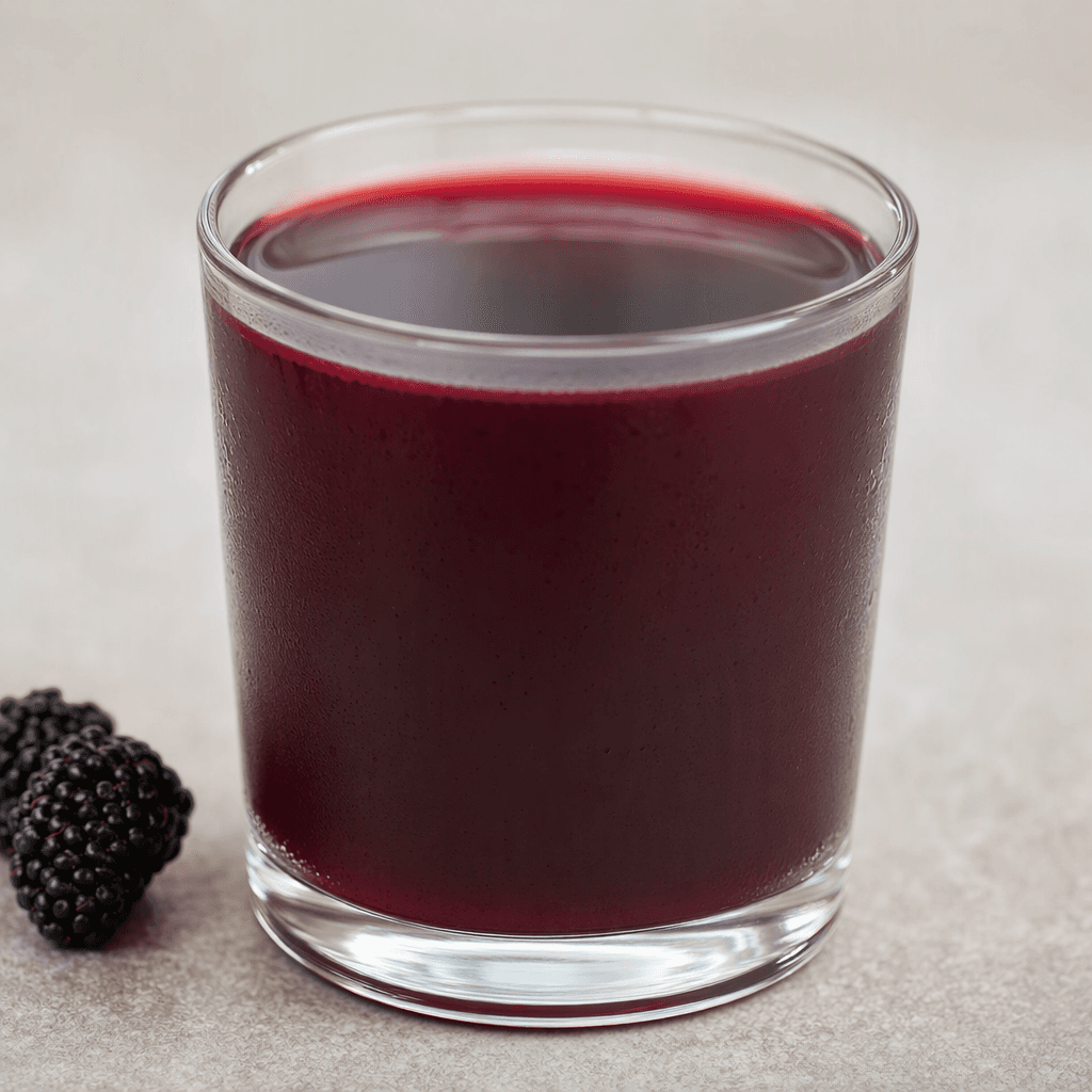 A deep purple-red black mulberry drink fills a clear glass, with a smooth, slightly translucent surface.