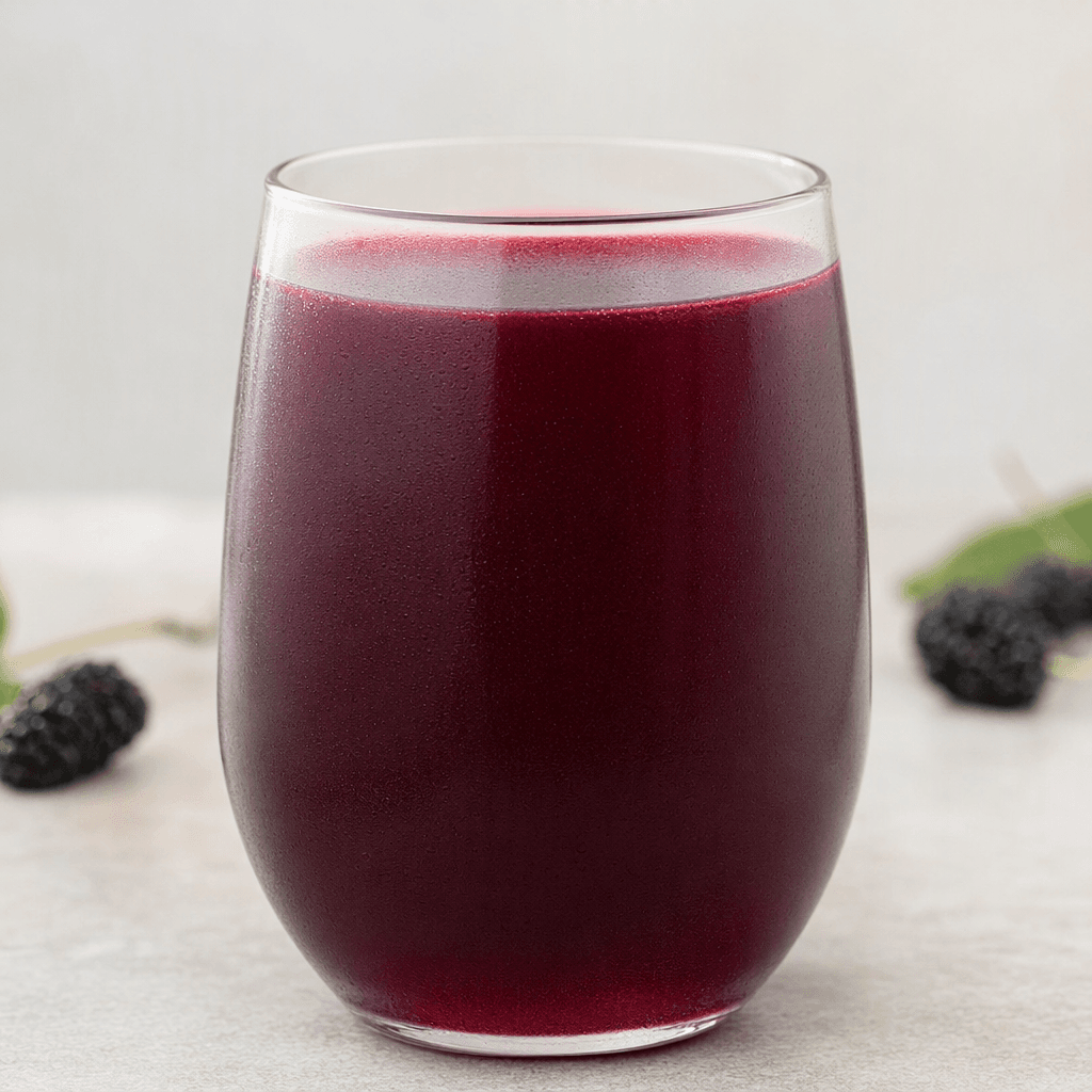 A deep purple-red black mulberry drink fills a clear glass, with a smooth, slightly translucent appearance.