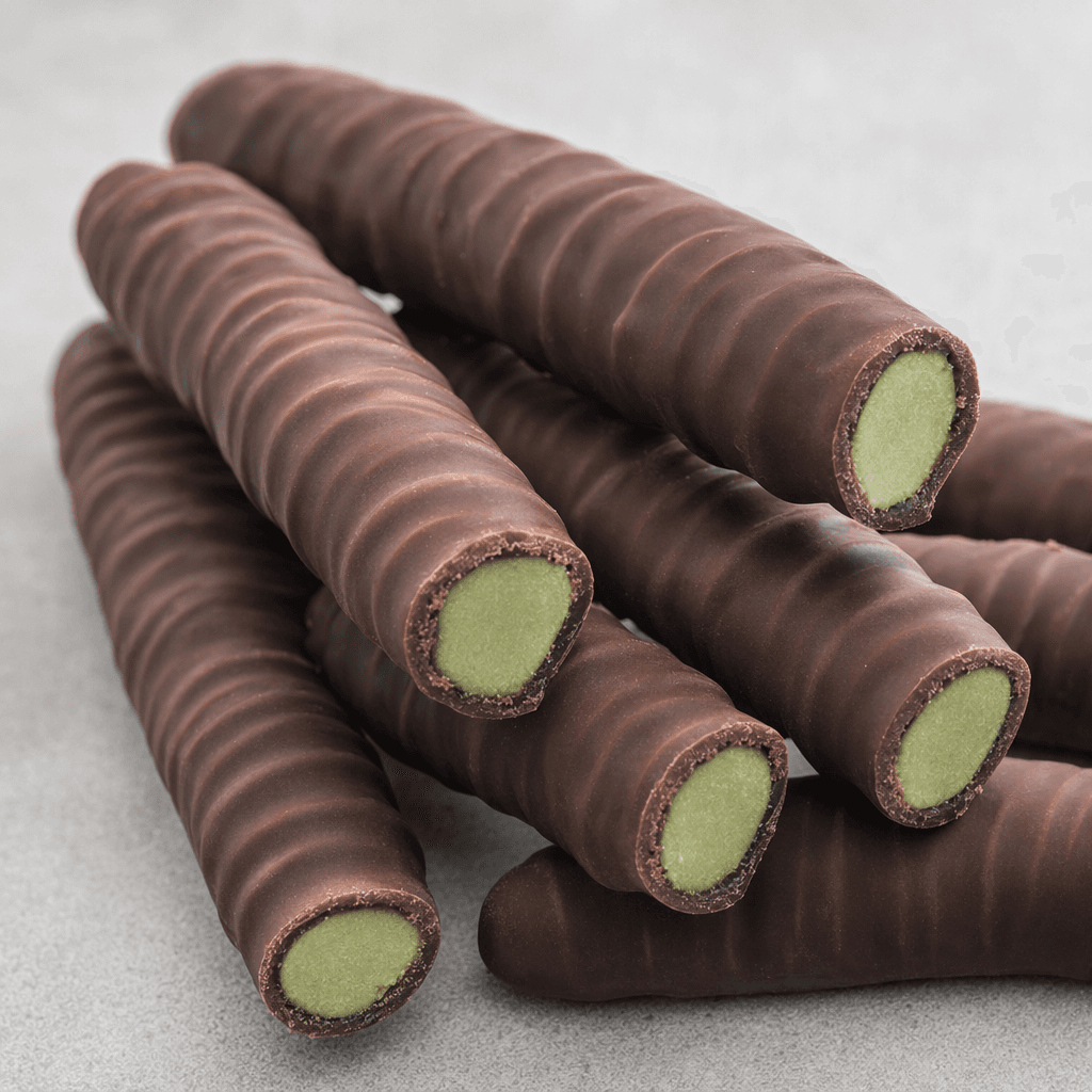 Several slender, finger-shaped biscuit sticks are coated in smooth dark chocolate, with pale green filling visible at their ends and a lightly ridged surface.