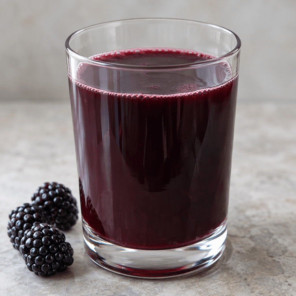 Deep purple-blackberry juice with a faint reddish sheen and a smooth, slightly cloudy appearance sits in a clear glass.