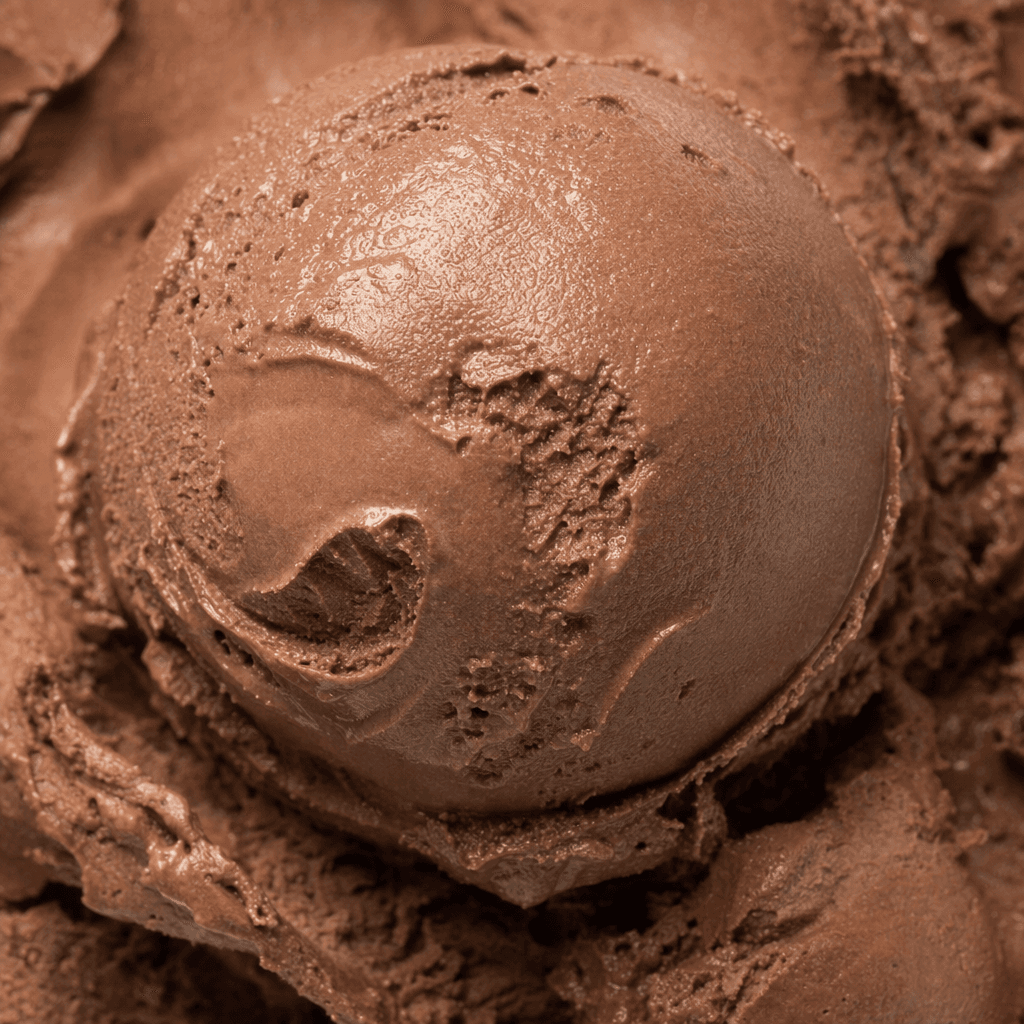 A rounded scoop of deep brown chocolate ice cream with a smooth, creamy surface and soft spoon-made ridges.