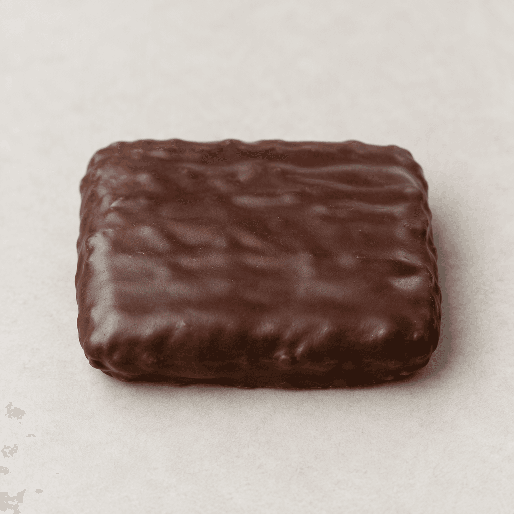 A small, flat, rectangular biscuit with rounded corners, completely covered in a smooth dark-brown chocolate coating, with a few subtle ridges and slightly uneven edges, presented on a plain surface.