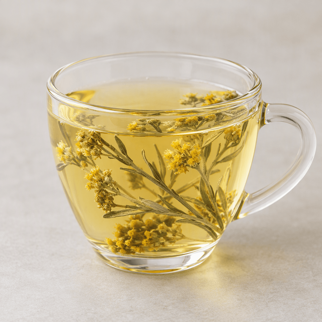 Pale golden, clear herbal infusion in a small glass cup, with a few slender gray-green stems bearing tiny yellow flowers visible inside.