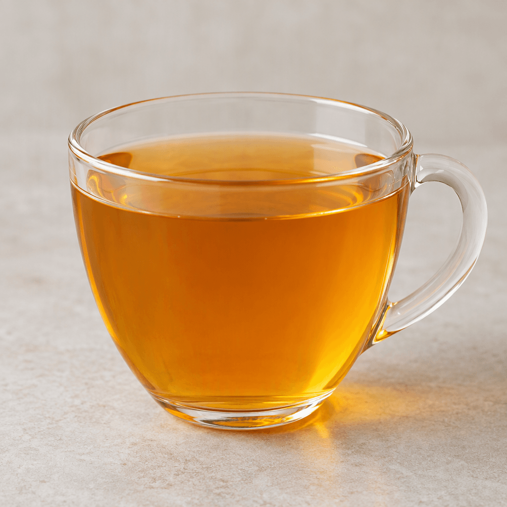 A clear golden-amber apricot infusion sits in a transparent cup, with no visible fruit pieces.