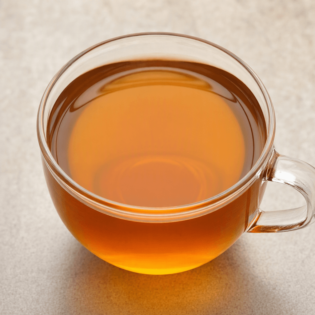 A clear, warm amber-brown herbal infusion in a transparent cup, with no visible pieces or garnish.