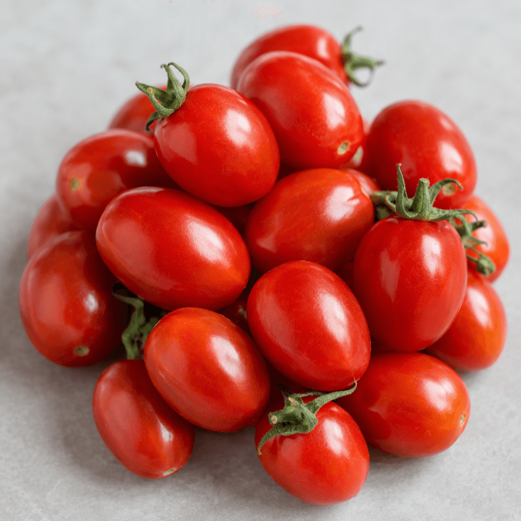 Small, smooth-skinned, oval tomatoes with a firm, glossy surface, ranging from bright red to deep red and sometimes showing short green stems.