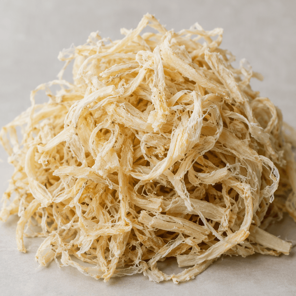 Pale beige, fibrous strands form a loose, slightly tangled mound with an uneven, dry-looking texture.