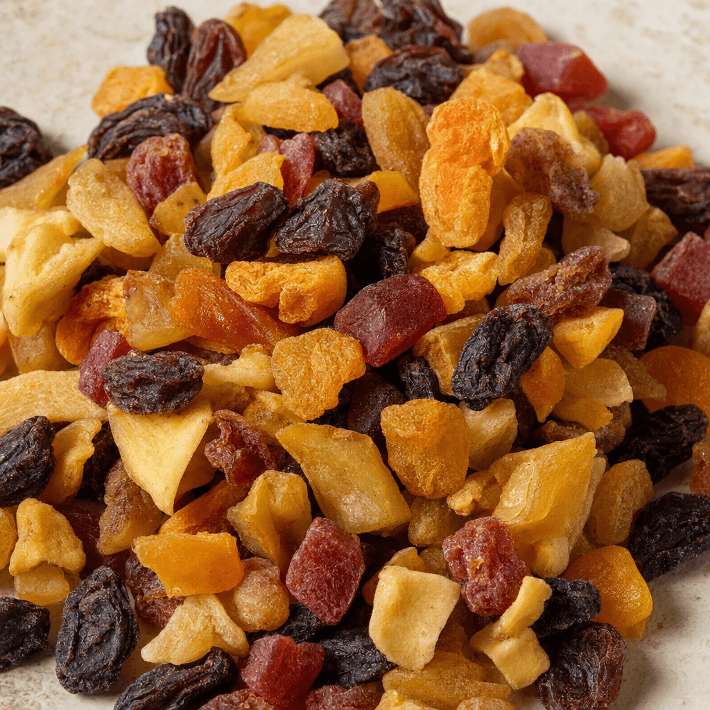 A loose pile of assorted dried fruit pieces in varied sizes and irregular shapes, with wrinkled, slightly leathery surfaces and shades of golden yellow, amber, orange, red, and deep brown.