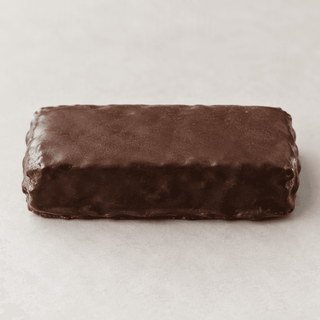 A rectangular, dark-brown protein bar with a smooth chocolate coating and slightly uneven edges, shown whole.