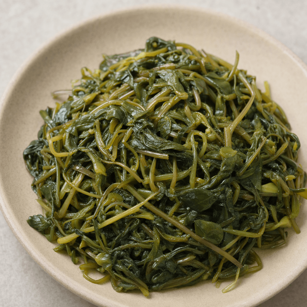 Soft, wilted purslane leaves and slender stems, glossy olive green with a few darker pieces, are loosely piled on a plate.