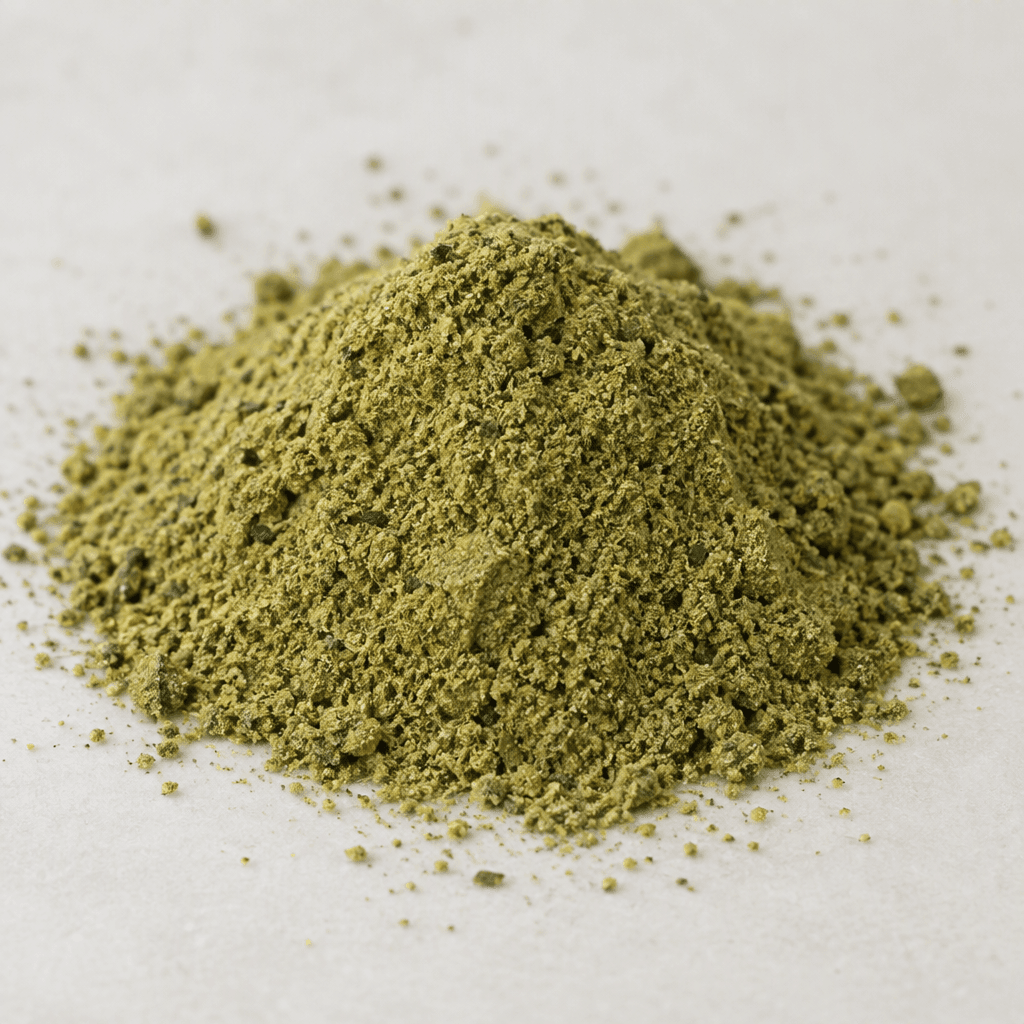 A small mound of fine, matte olive-green powder with a few darker flecks, loosely scattered on a plain surface.