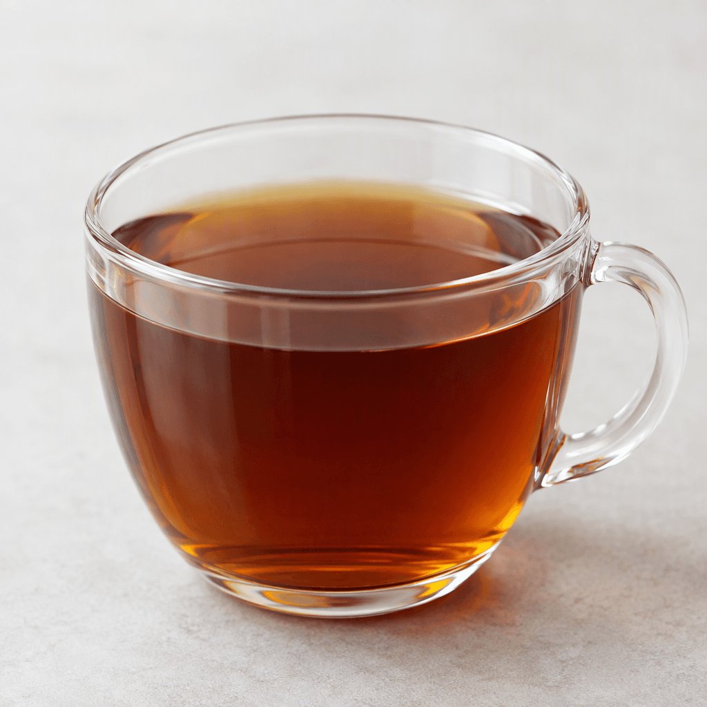 A clear cup holds a smooth, translucent deep amber-brown chicory infusion, with no visible leaves or garnish.