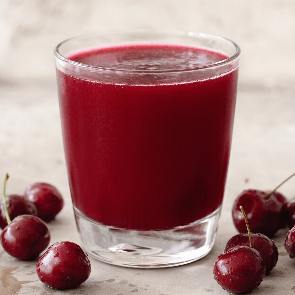 A deep ruby-red sour cherry drink with a smooth, slightly opaque appearance fills a clear glass.