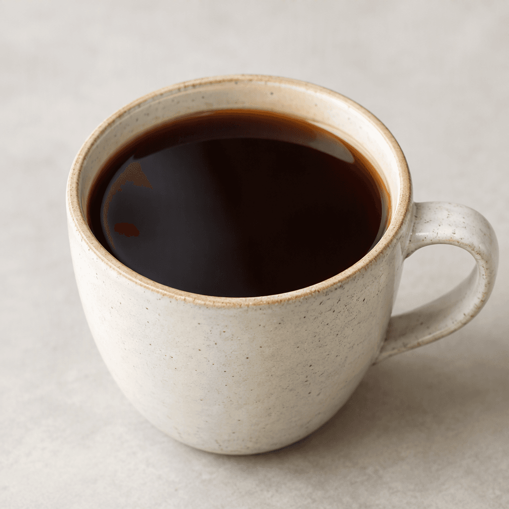 A cup of clear, deep-brown filter coffee with a smooth surface and no visible foam.