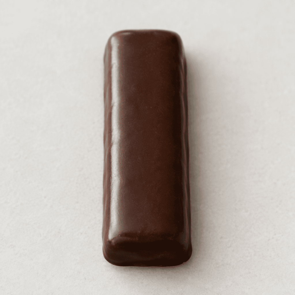 A slim, elongated rectangle of dark brown chocolate with gently rounded edges and a smooth, slightly glossy surface.