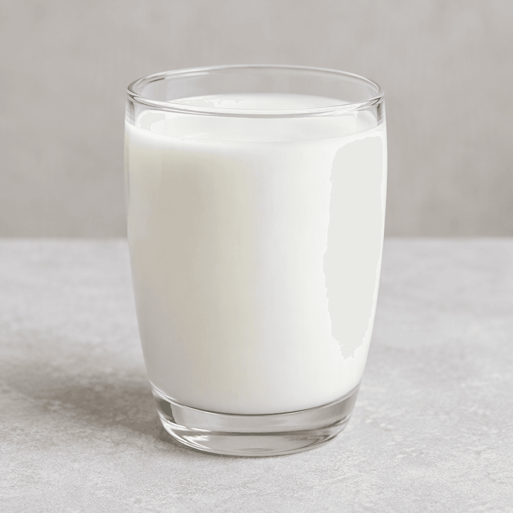 An opaque, bright-white liquid with a smooth, even surface sits in a clear glass.