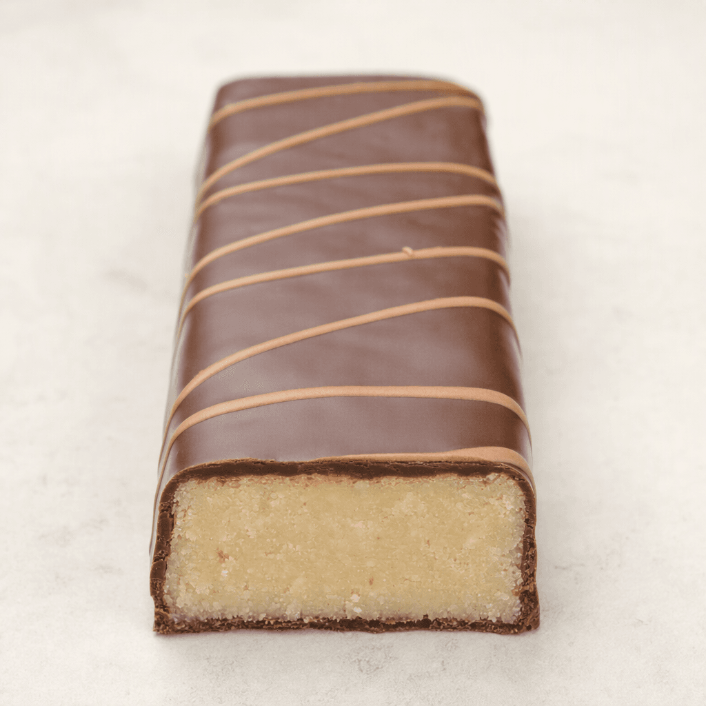 An oblong, rectangular bar with a smooth chocolate-brown coating, a thin contrasting drizzle across the top, and a pale, dense interior visible at the cut end.