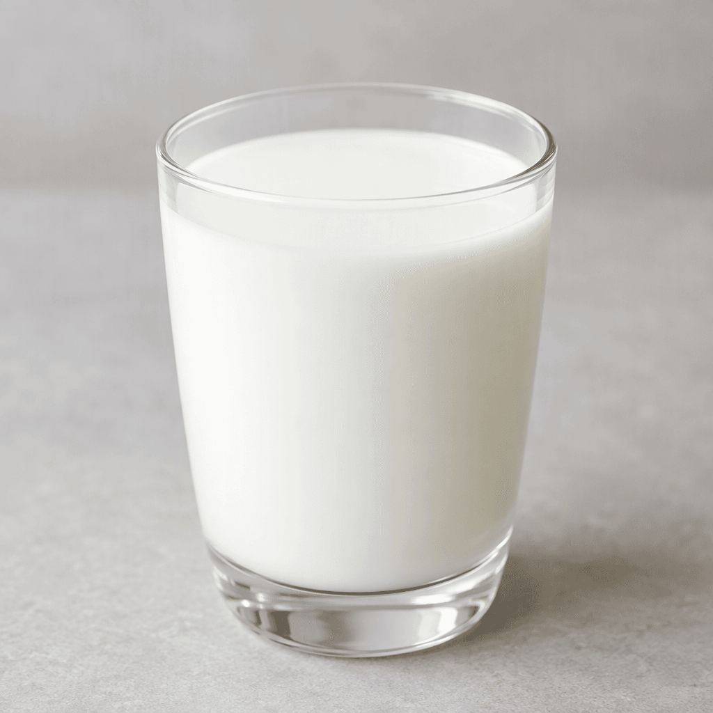 A smooth, opaque white liquid fills a clear glass, with an even surface and no visible sediment.