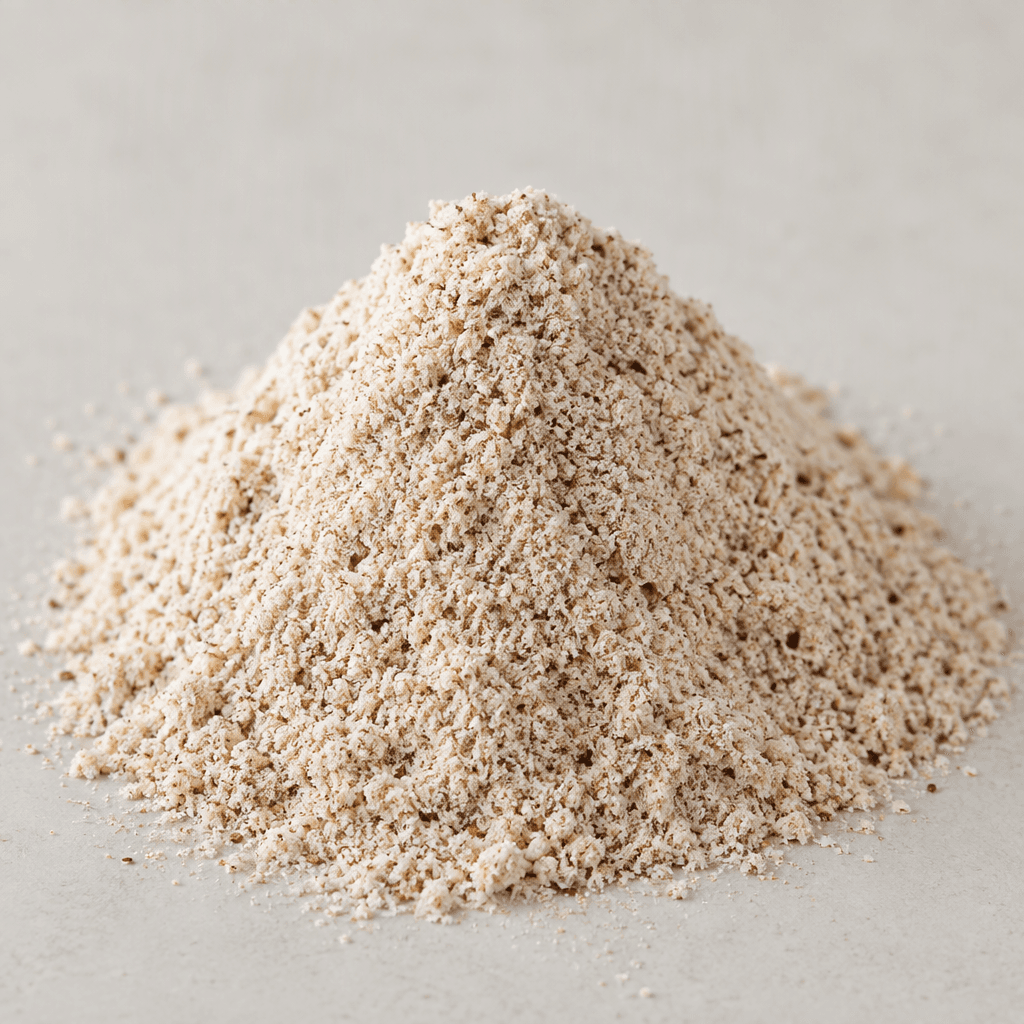 A small mound of fine, loose pale-tan rice flour with a few darker brown specks sits on a plain surface.