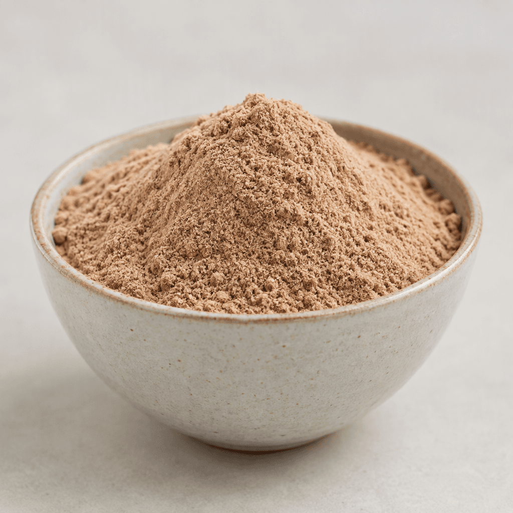 A mound of fine, light-brown protein powder with a soft, even texture sits in a small bowl.