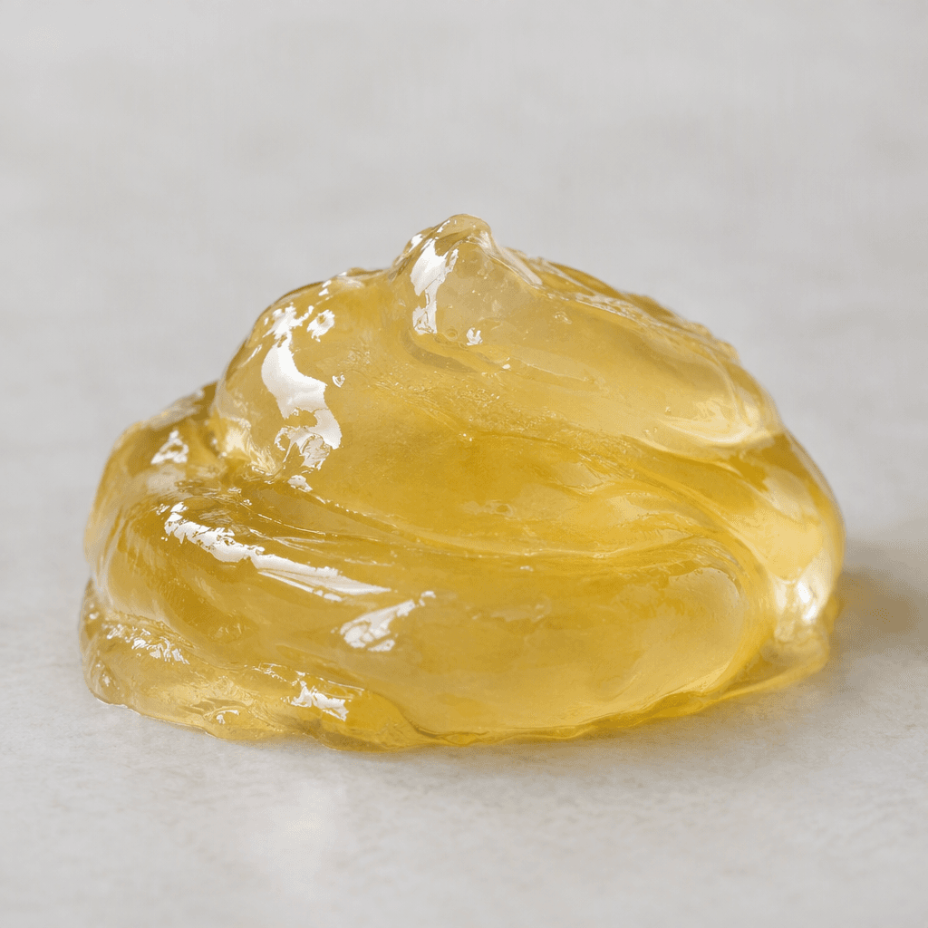 A small serving of thick, smooth, glossy energy gel sits in a soft mound, translucent and pale golden in colour.