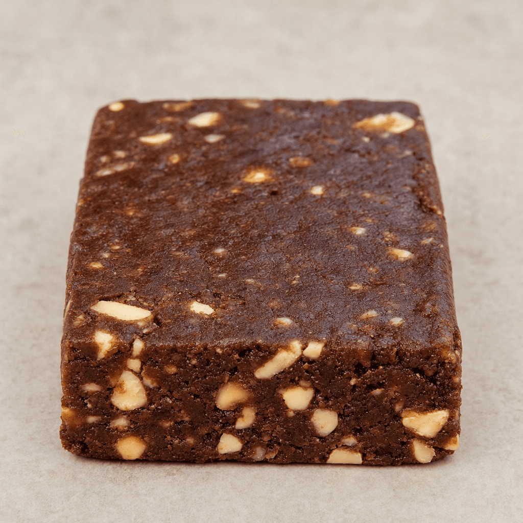 A compact rectangular chocolate-brown bar with a slightly uneven surface and visible hazelnut pieces.