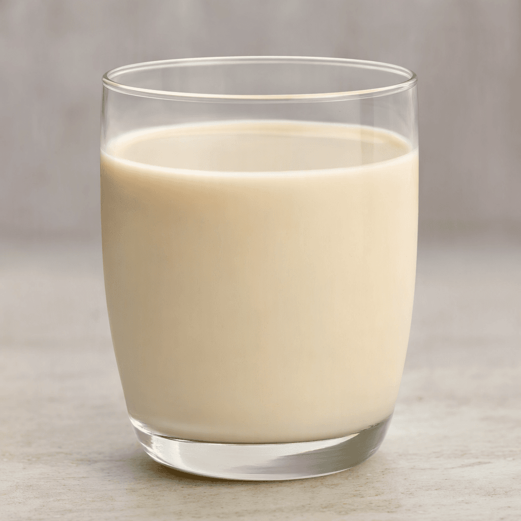 Pale beige, opaque hazelnut milk with a smooth, even texture, served in a clear glass.