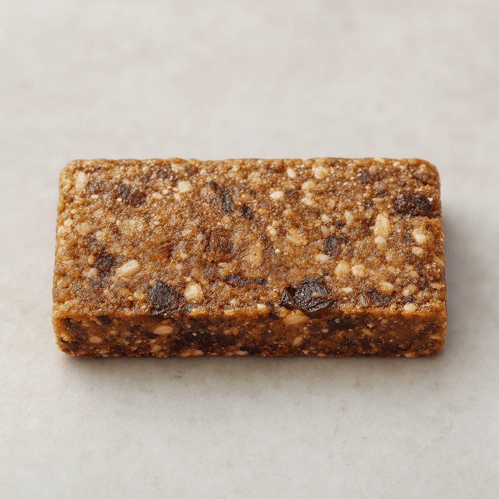 A compact, rectangular brown snack bar with a slightly uneven, textured surface and visible bits embedded throughout.