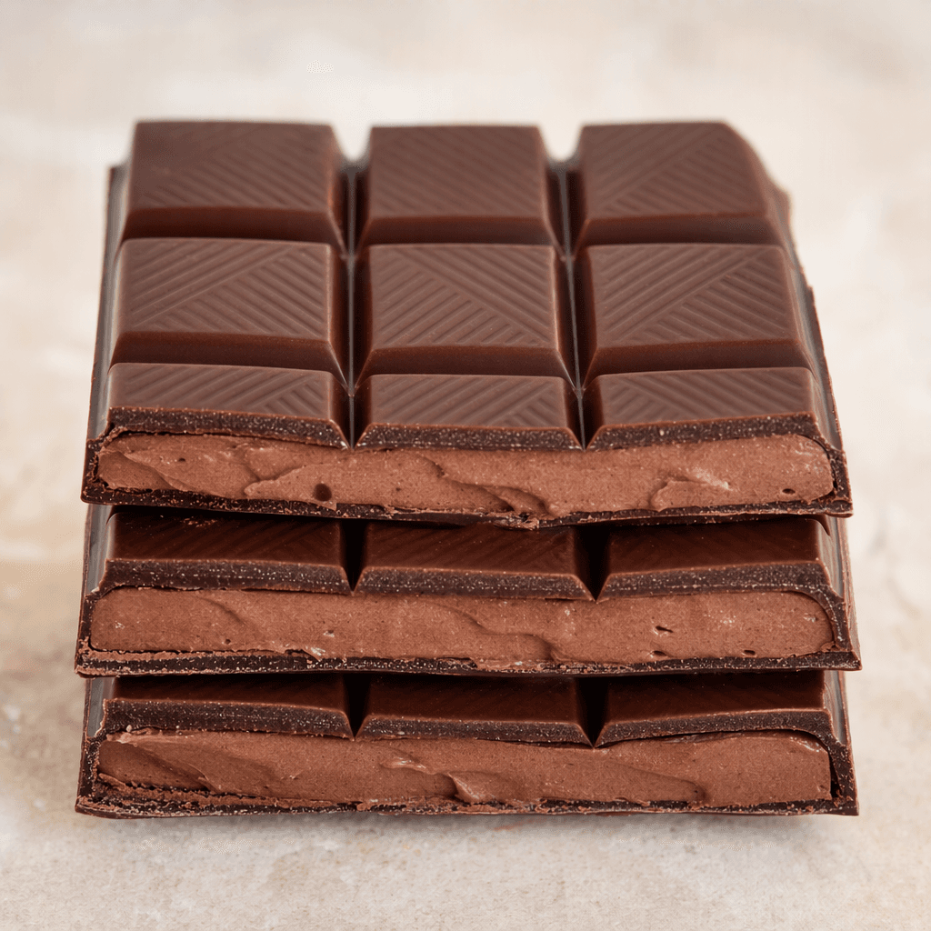 A dark brown chocolate bar divided into neat rectangular segments, with a smooth, thick cocoa-cream filling visible between the chocolate layers.