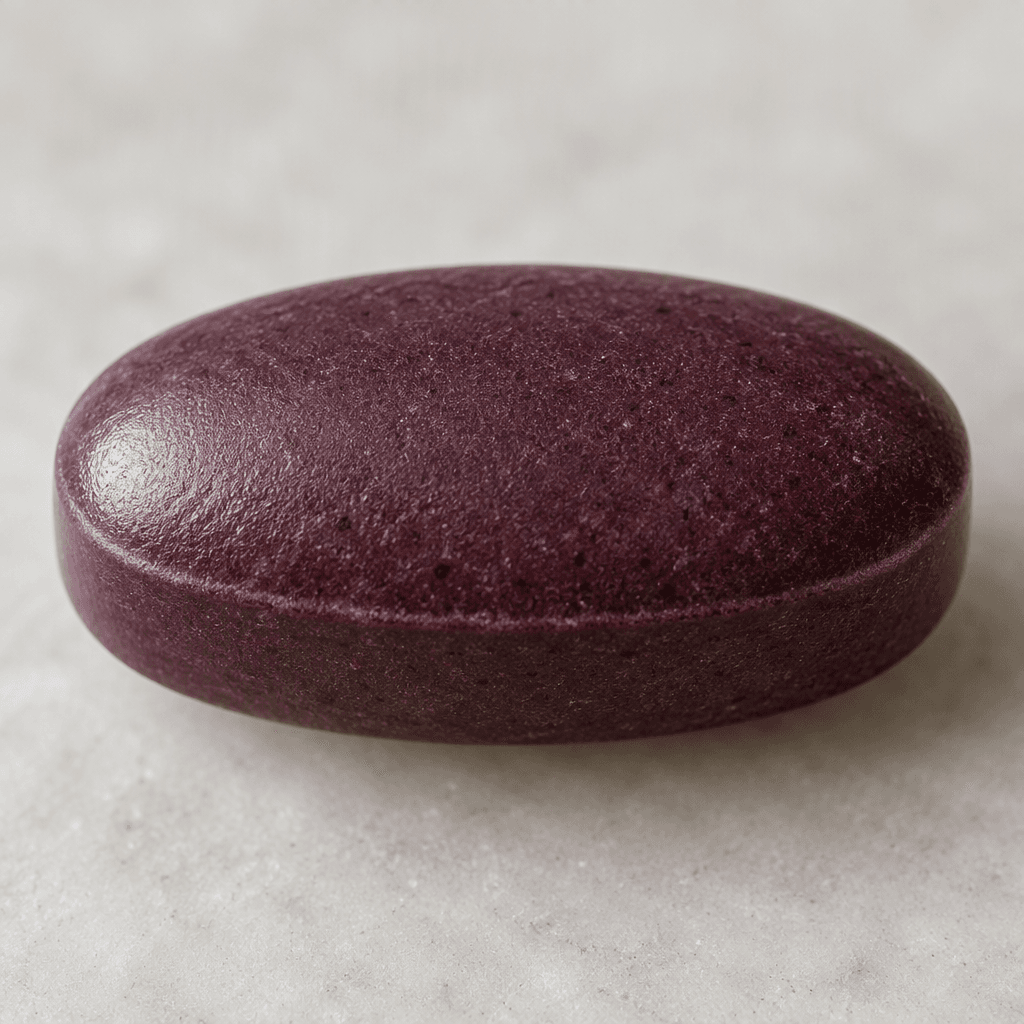 A large, smooth, deep purplish-brown oval tablet with softly rounded edges.