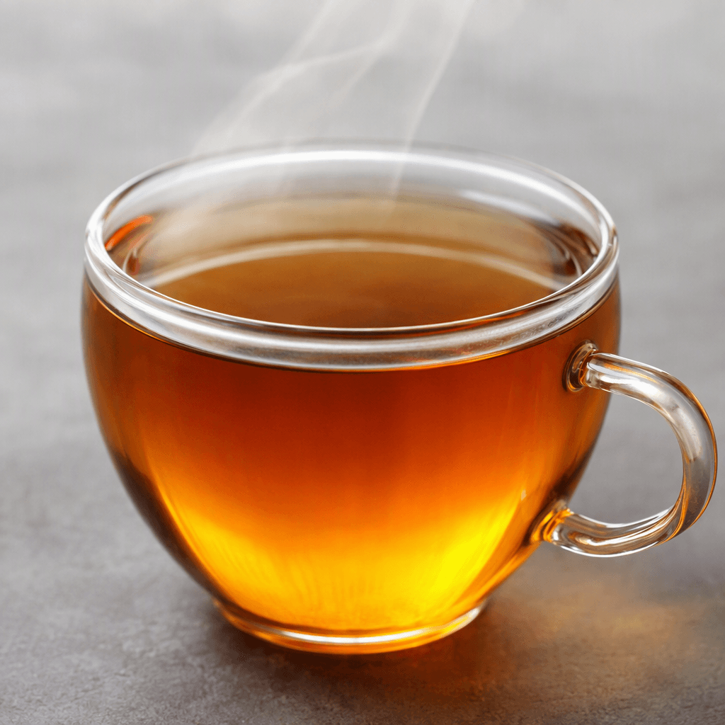 A clear amber-brown beverage with a warm golden glow, served steaming in a transparent glass or ceramic cup, with a smooth, liquid surface and no visible ingredients.