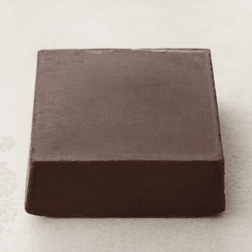 A solid, dark-brown rectangular cocoa bar with a firm, slightly matte surface and subtly uneven edges.
