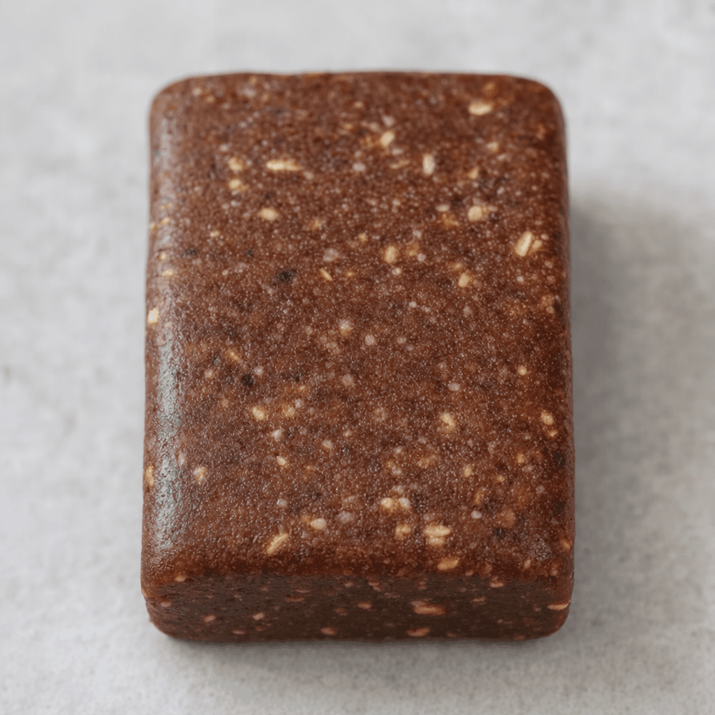 A compact, rectangular chocolate-brown bar with rounded edges and a dense, slightly textured surface.