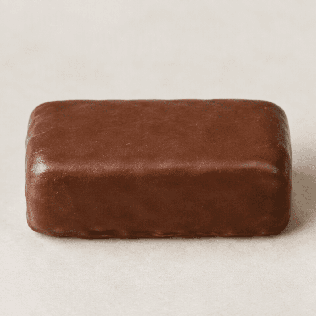 A compact, rectangular chocolate-brown bar with softly rounded edges and a smooth, slightly glossy surface, shown whole.