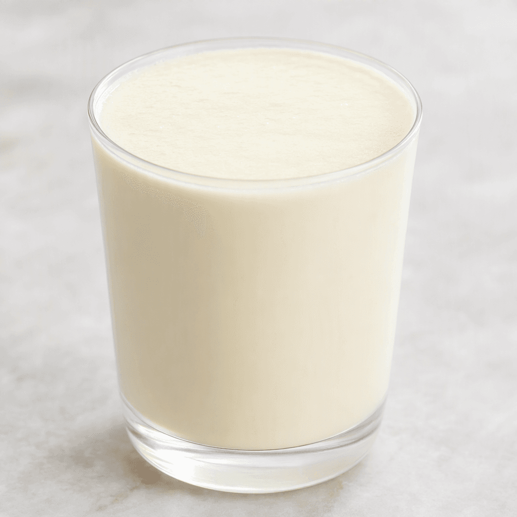 A smooth, opaque, pale ivory drink served in a small clear glass.