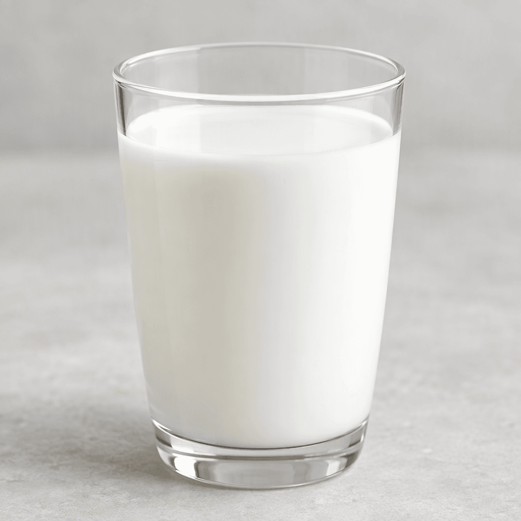 Smooth, opaque white milk with a uniform, slightly glossy surface, poured into a clear glass.